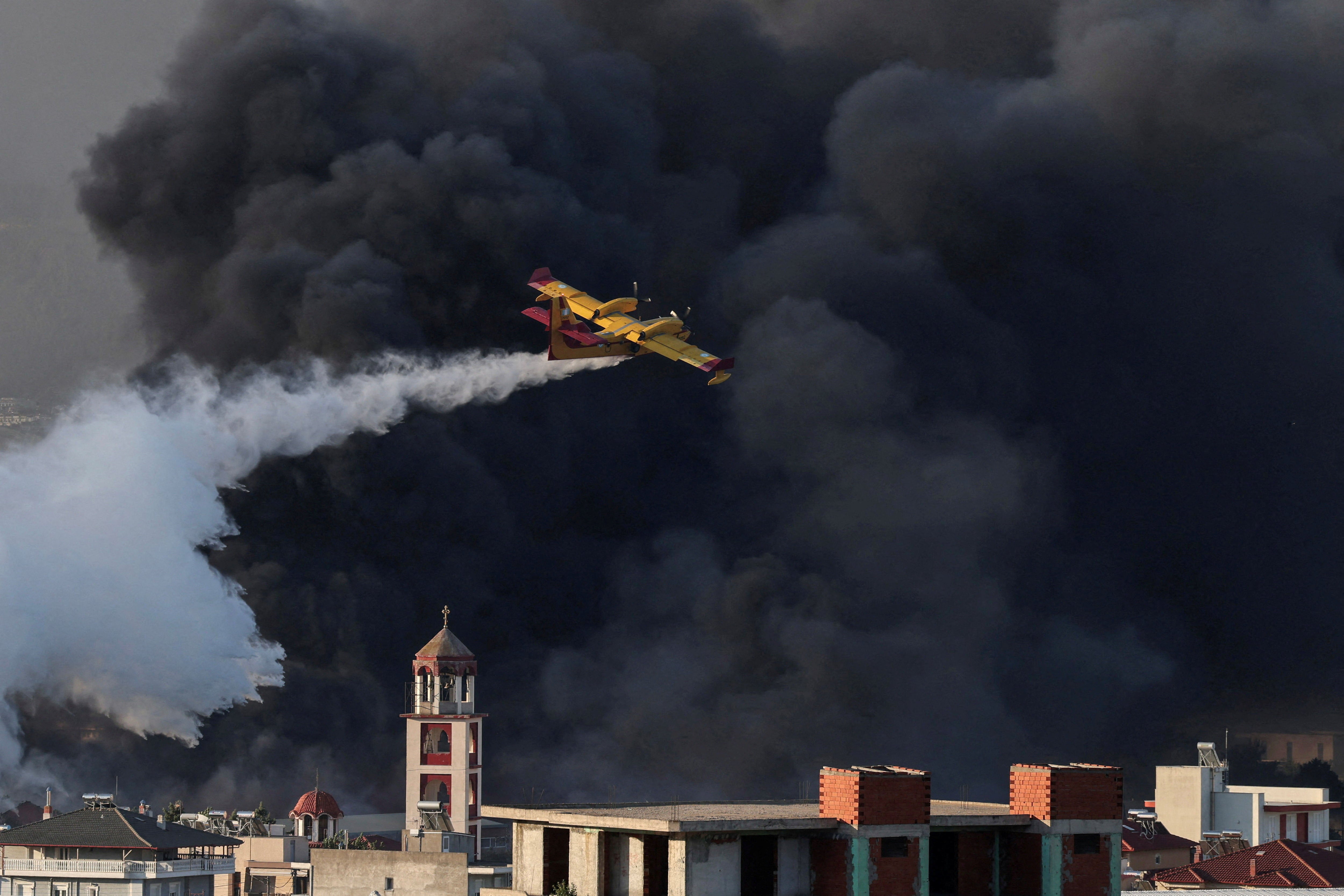 A Canadair firefighting plane drops water at a burning recycling factory in Oreokastro, on the outskirts of Thessaloniki, Greece, July 5, 2026.