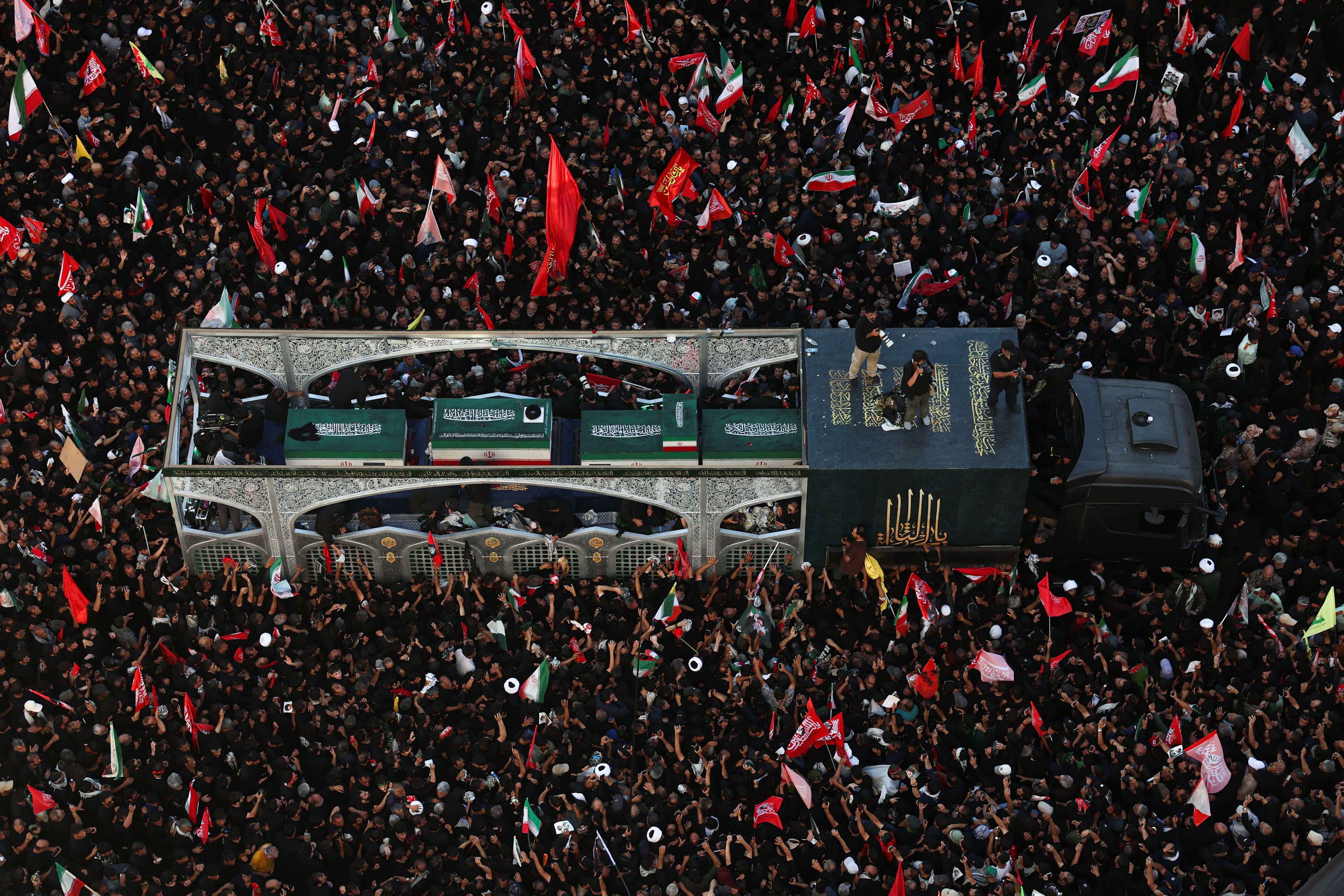 Mourners gather around a vehicle transporting the coffin of Iran's late supreme leader Ayatollah Ali Khamenei