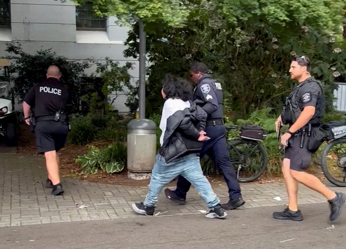 A suspect in the shooting is led away by police