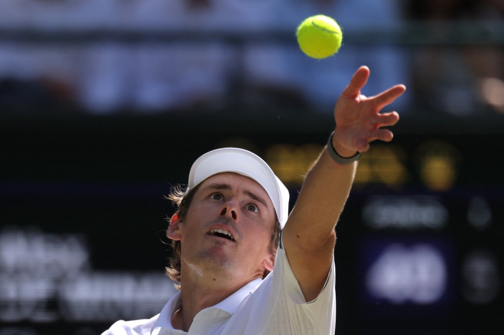 Australia's Alex de Minaur preparing to serve during a tennis match.