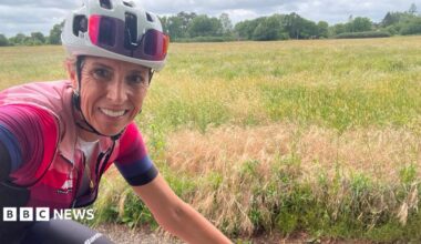 Michelle Sharland standing with her bike in front of an olive tree