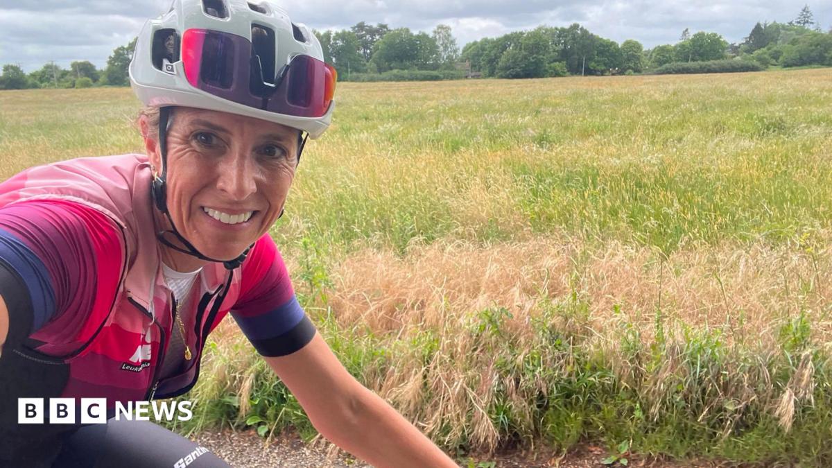 Michelle Sharland standing with her bike in front of an olive tree