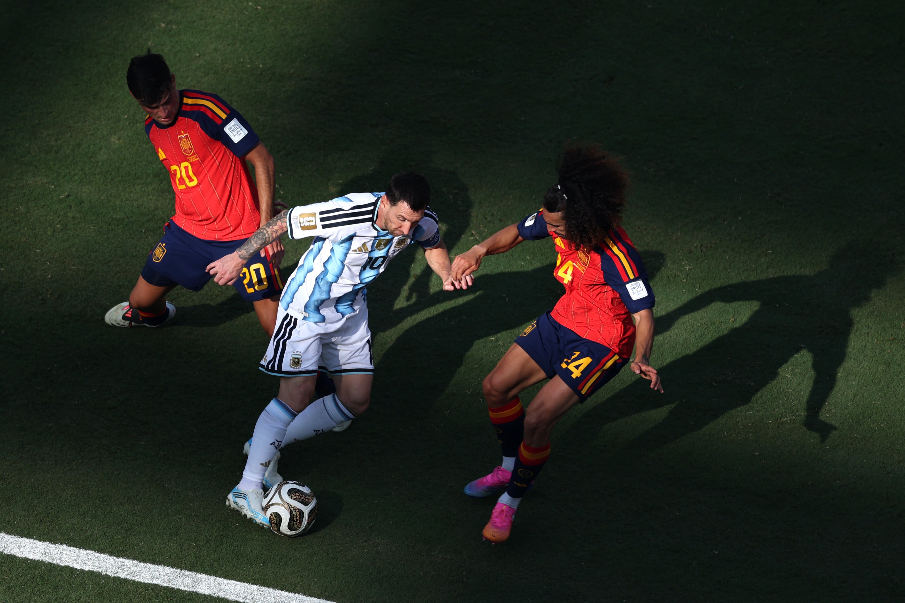 Lionel Messi #10 of Argentina controls the ball against Pedri #20 and Marc Cucurella #24 of Spain