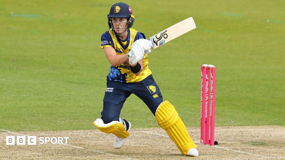 Heather Graham batting for Hampshire in a yellow helmet and shirt and dark blue trousers with yellow cricket pads