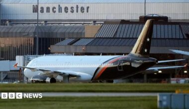General view of an aircraft at Manchester Airport outside the grey terminal