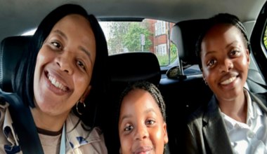 A smiling family sat together in the back seat of a car