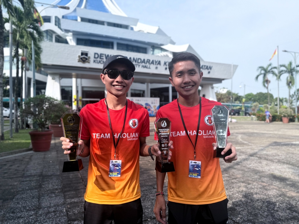 The twin brothers, Syahrullah and Hazarullah, proudly shows their trophies at the Kuching Half Marathon Heritage Run 2026. — The Borneo Post pic