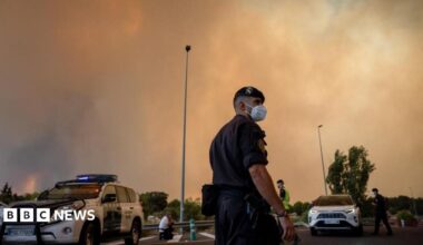 A person runs as the fire spreads in the mountains of Navaluenga, Avila, Spain