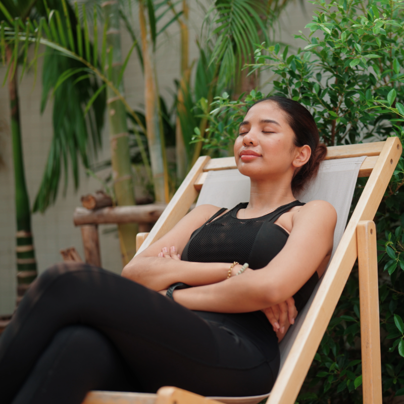 what-attracts-mosquitoes person relaxing on a deck chair in a garden setting.