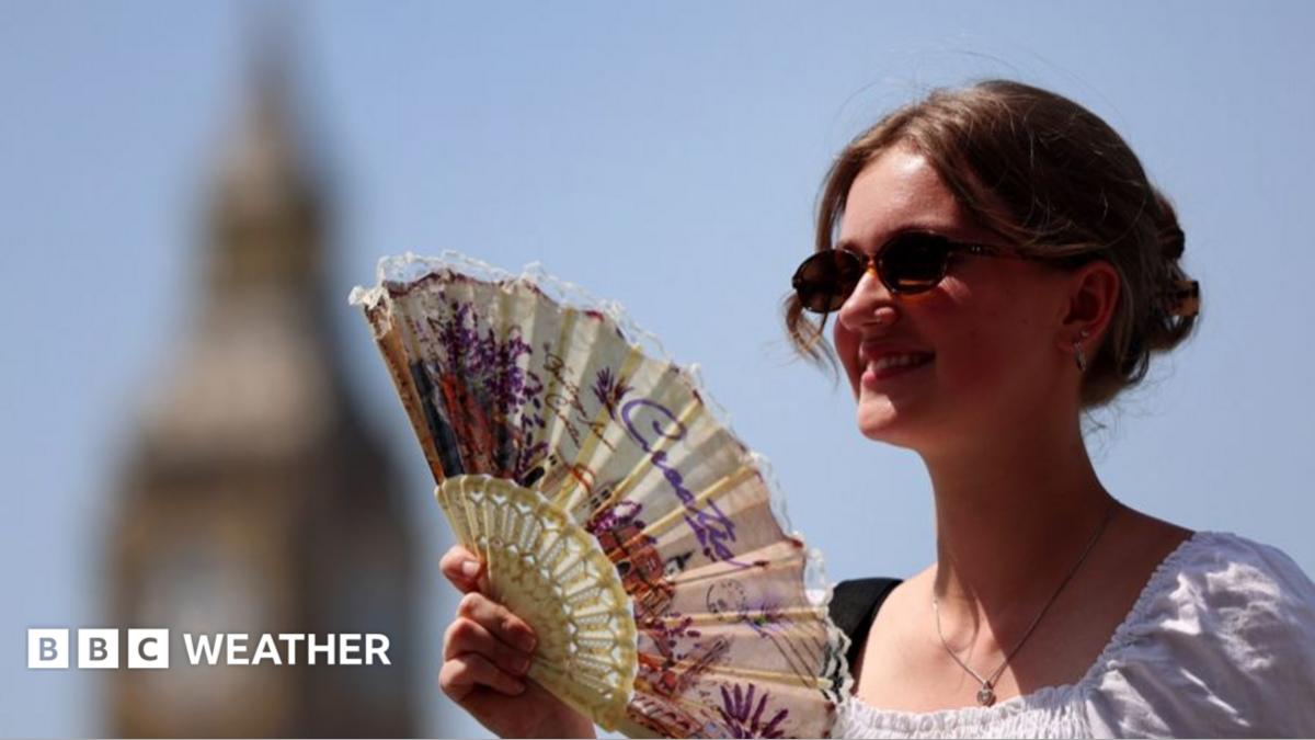 A woman uses a fan in London during a late-June heatwave