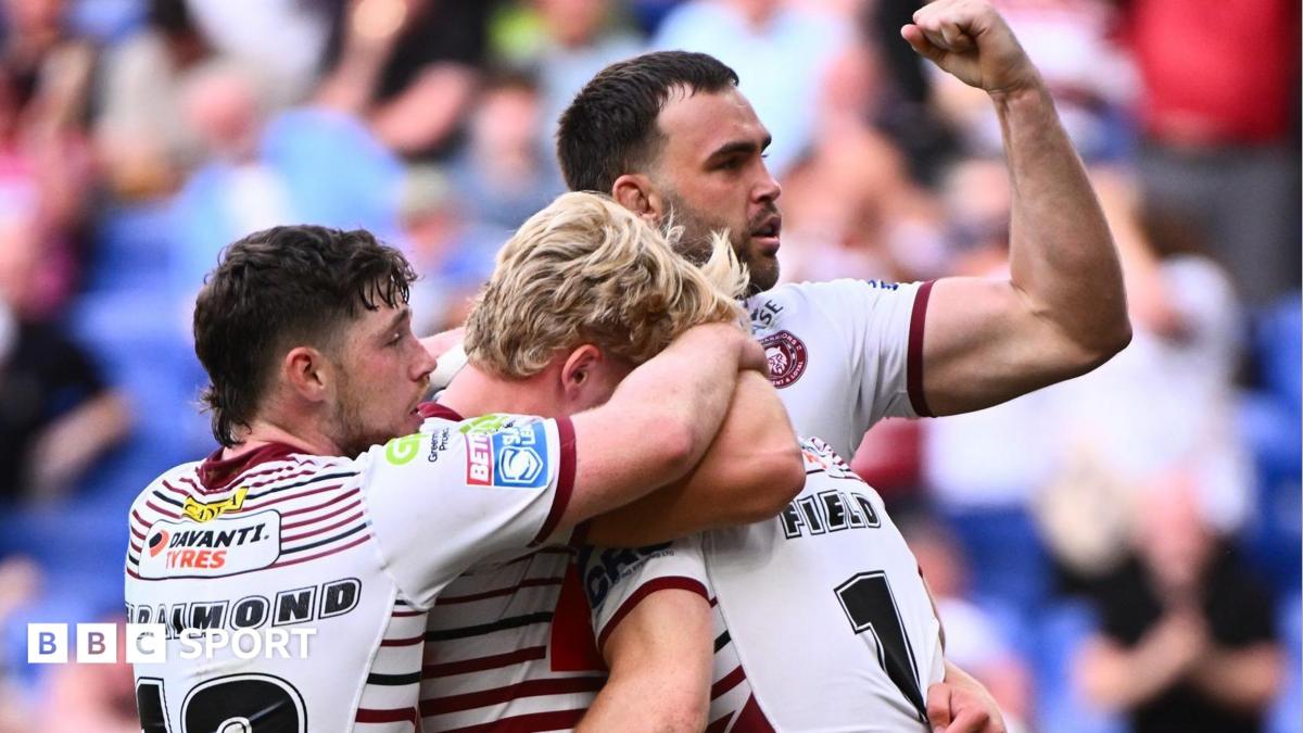 Jai Field is engulfed by Wigan Warriors team-mates after scoring against St Helens