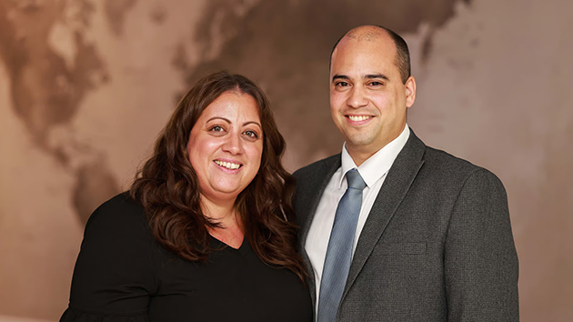 Wederly Aguiar (right) and his wife, Sally Aguiar (left), smile following Aguiar’s re-election as Treasurer of the British Union Conference