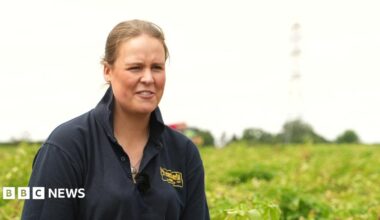 Polly Megginson pictured in a farmer's field. She has fair-coloured hair and is wearing a blue polo shirt.