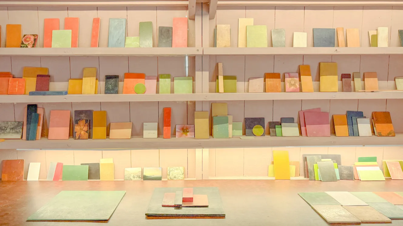 The Golden Shed at Holkham with a large collection of colorful squares and rectangles displayed on shelves and tables.