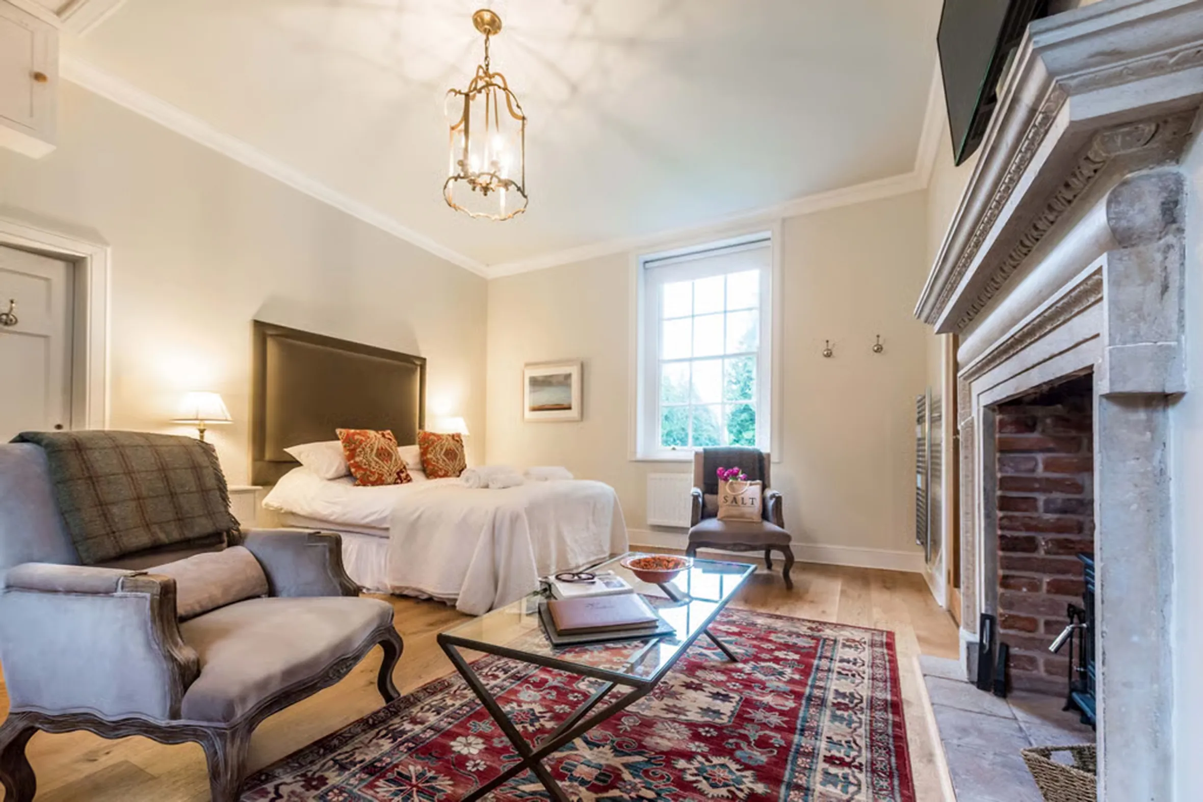 Bedroom at Palmers Folly, Holkham, with a bed, chairs, and fireplace.