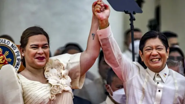 Philippine Vice-President Sara Duterte raises the hand of President Ferdinand Bongbong Marcos