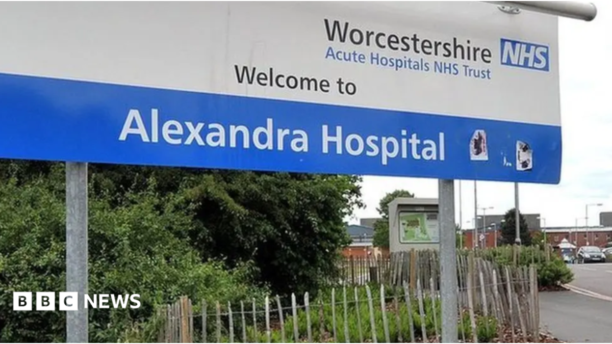 A blue and white hospital sign on a roadside, which reads Worcestershire Acute Hospital NHS Trust Welcome to Alexandra Hospital