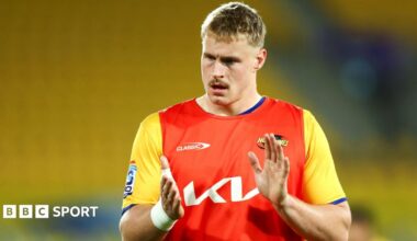 Tom Allen applauds in the red and yellow jersey of Hurricanes