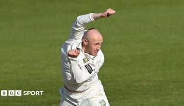 Left-arm spin bowler Callum Parkinson just after completing a delivery with his left arm tucked in and his right arm raised over his head