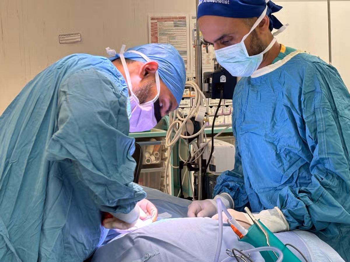 Surgeons operating on Ralph Seed, a teenager who is the first in the UK to have a new implant