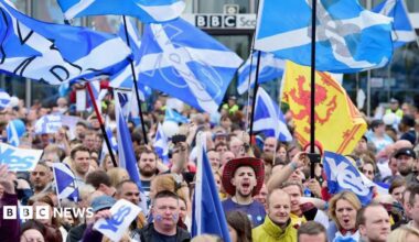 hundreds of marchers holding up Yes Scotland flags