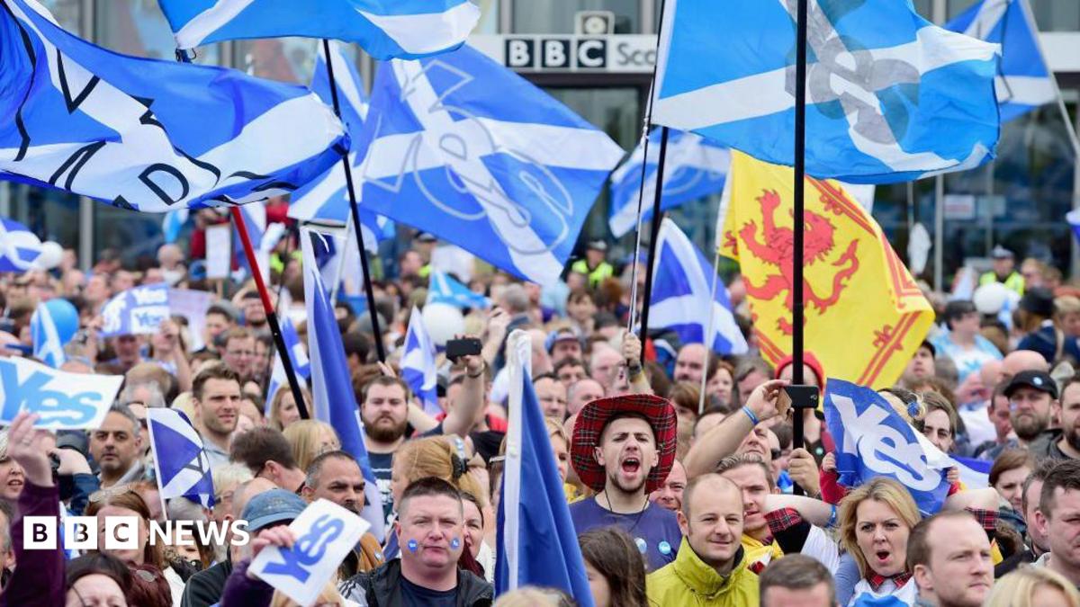 hundreds of marchers holding up Yes Scotland flags