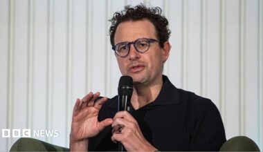 Anthropic chief executive Dario Amodei speaks through a microphone during a summit