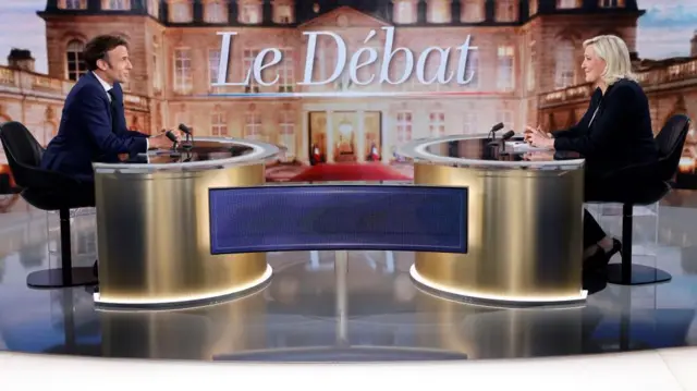 French President and La Republique en Marche (LREM) party candidate for re-election Emmanuel Macron (L) and French far-right party Rassemblement National (RN) presidential candidate Marine Le Pen (R) sit prior to taking part in a live televised debate on French TV channels TF1 and France 2 in Saint-Denis in April 2022"