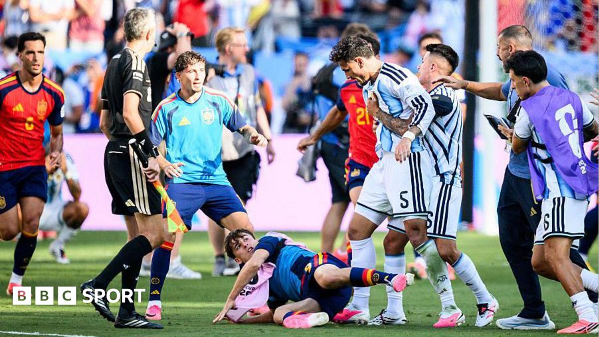 Leandro Parades (fourth right) is pulled away by teammates with a Spain player on the floor at his feet