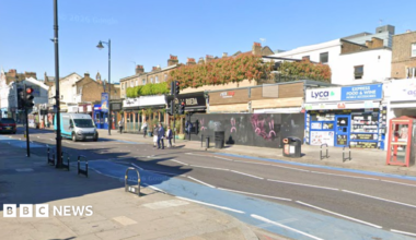 A screenshot from Google Streetview shows a view of shops on Clapham High Street, close to Tremadoc Road. The archive picture shows people crossing the street as a van waits at traffic lights