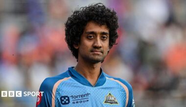R Sai Kishore standing on the pitch wearing a jersey for Gujarat Titans during a match in 2025
