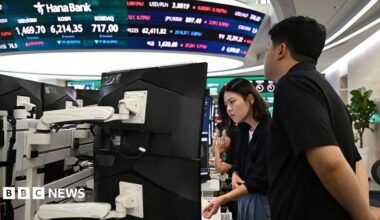 Currency dealers watch monitors as an electronic screen shows South Korea's benchmark stock index (KOSPI) in a foreign exchange dealing room at the Hana Bank headquarters in Seoul on July 28.