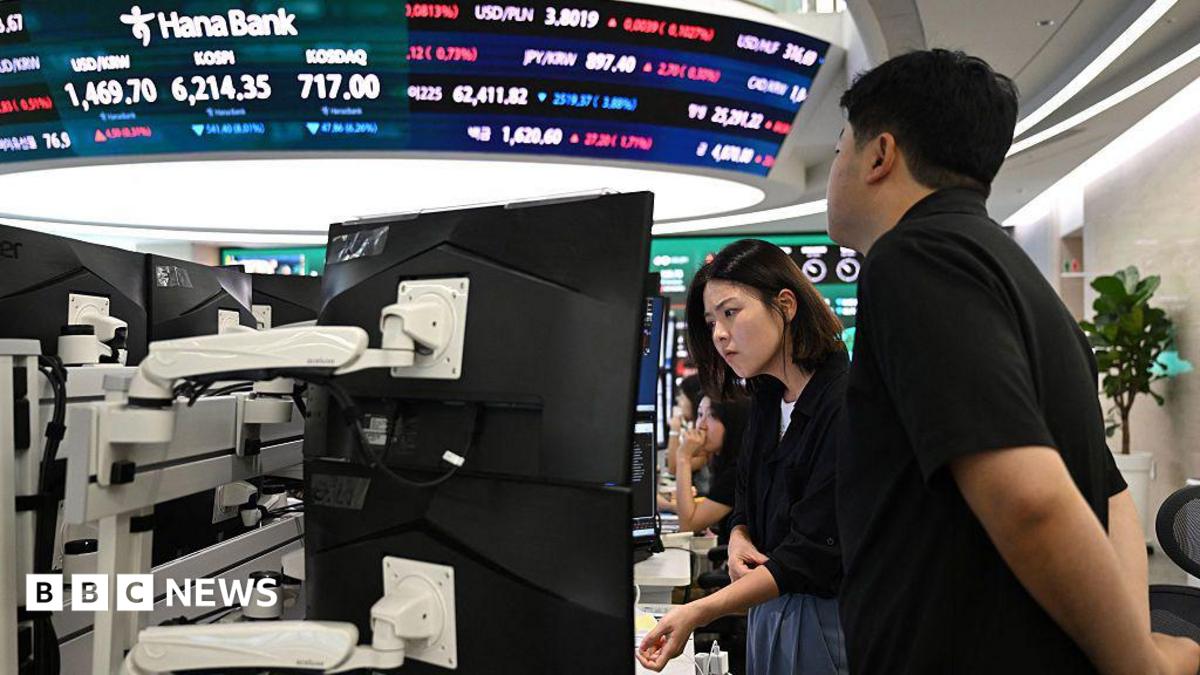Currency dealers watch monitors as an electronic screen shows South Korea's benchmark stock index (KOSPI) in a foreign exchange dealing room at the Hana Bank headquarters in Seoul on July 28.