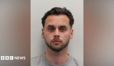 A custody image of a man with dark hair and a close cropped beard looking at the camera.