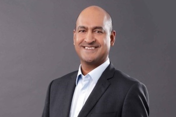 Man in suit smiles at camera.