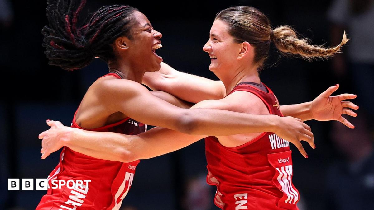 Fran Williams and Olivia Tchine, wearing England's red netball jersey, celebrate after beating South Africa to reach the semi-final by jumping in the air and hugging each other