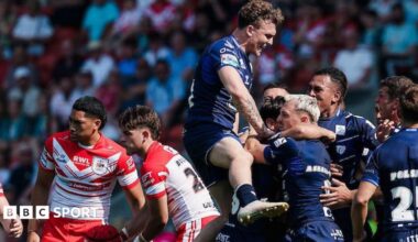 Toulouse players, in dark blue, celebrate a try against St Helens, two of whose players, in red and white, look disconsolate.
