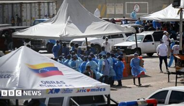Los Silos facilities, dominated by a large, 36-meter-tall tower. White tents and people in hasmat suits stand in front.