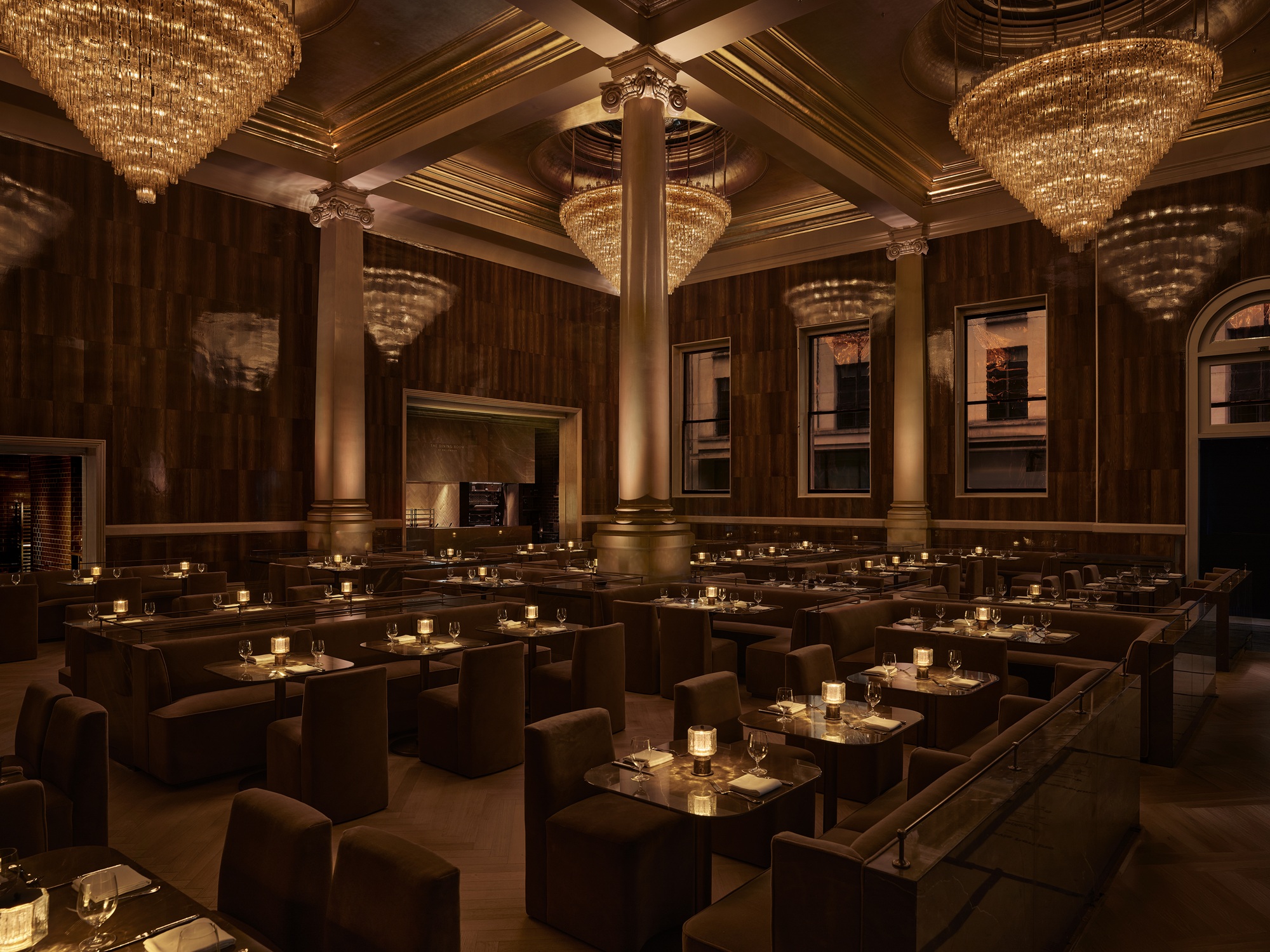 the dining room at rh london in mayfair, with large columns, chandeliers, and a gold-leaf ceiling