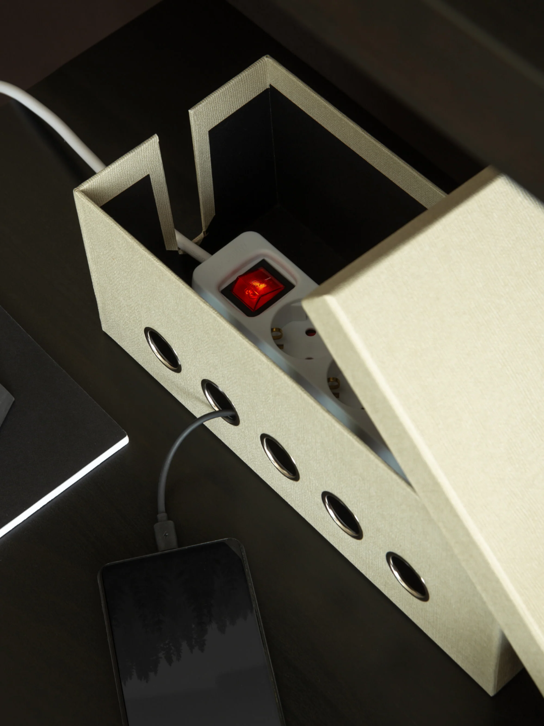 A light beige box with holes for cord management from Bigso Box of Sweden