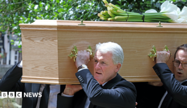 Mark Hughes is seen with others carrying his son's coffin into church