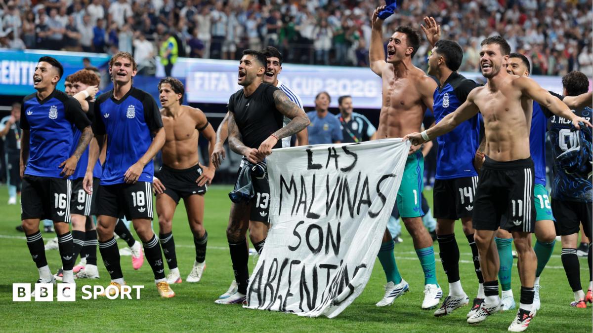 The Argentina players celebrate at full-time with a banner that reads "The Falkland Islands are Argentinian" during the World Cup 2026 semi-final between England and Argentina