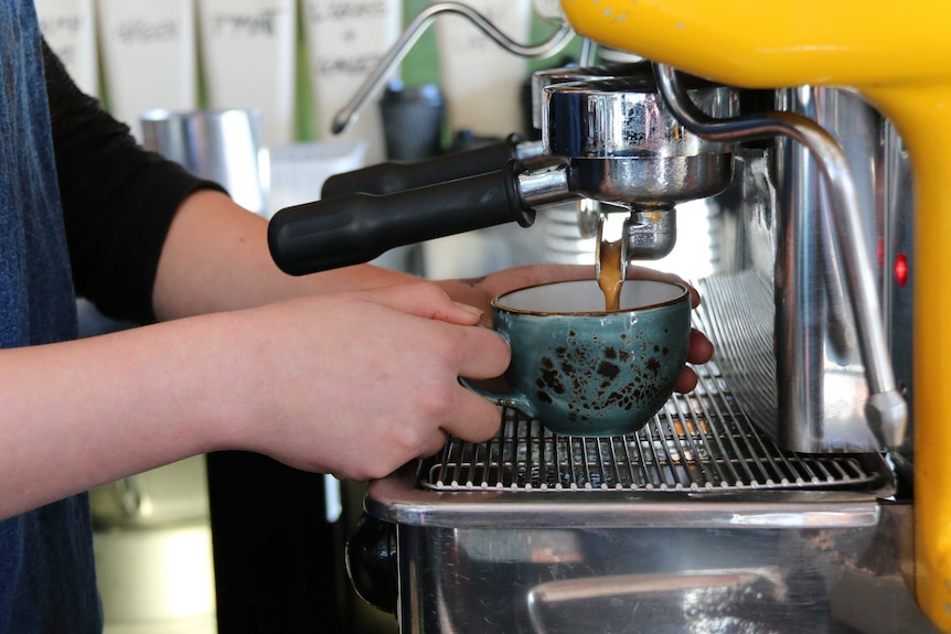 Close-up of barista using a coffee machine in Salamanca in Hobart in Tasmania, June 2015