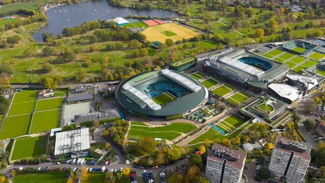 Aerial view of Wimbledon's iconic tennis courts, nestled amidst lush greenery and juxtaposed with the urban landscape, creating a captivating contrast