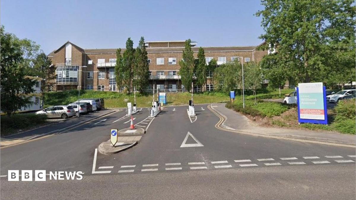 Entrance to hospital with a brown-bricked building in the background.