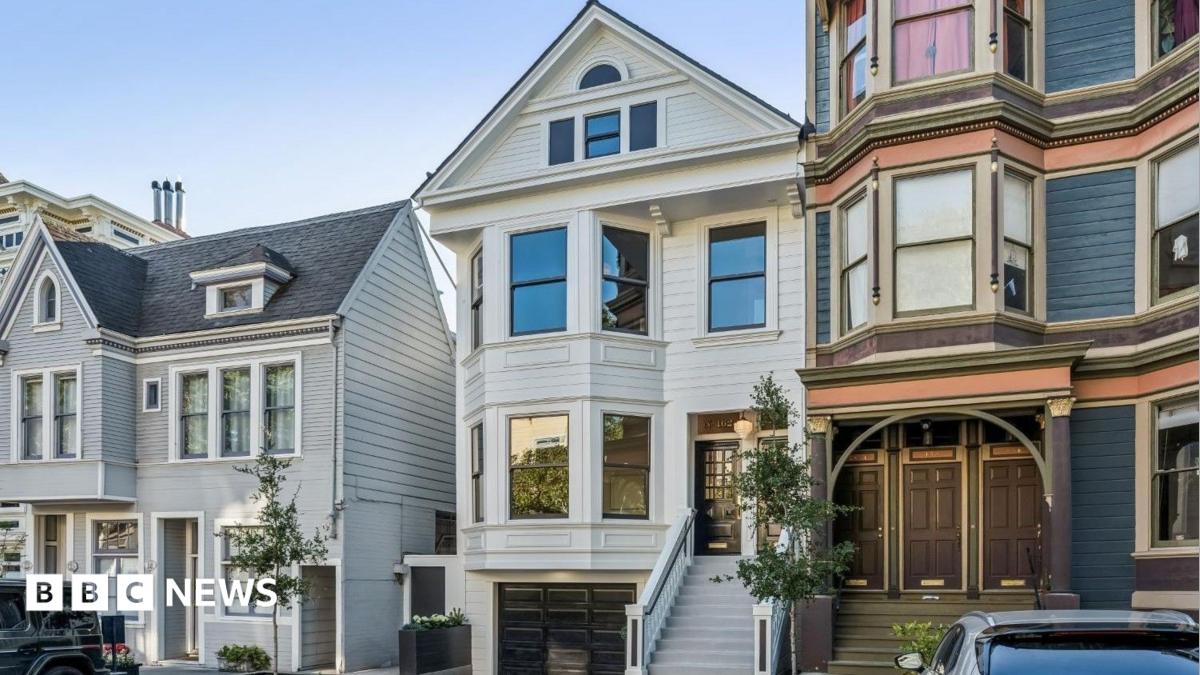 Three homes on a residential street in San Francisco. The three floor homes look clean and well maintained with well-trimmed plants and trees outside.