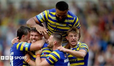 Joe Philbin is mobbed by Warrington Wolves team-mates after scoring a try against Hull KR.