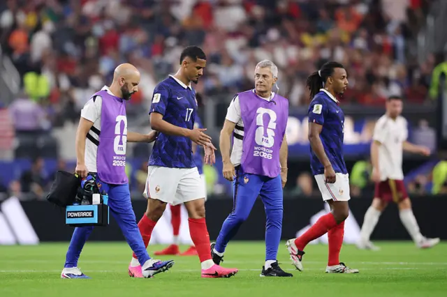 Saliba walks off alongside the France physios