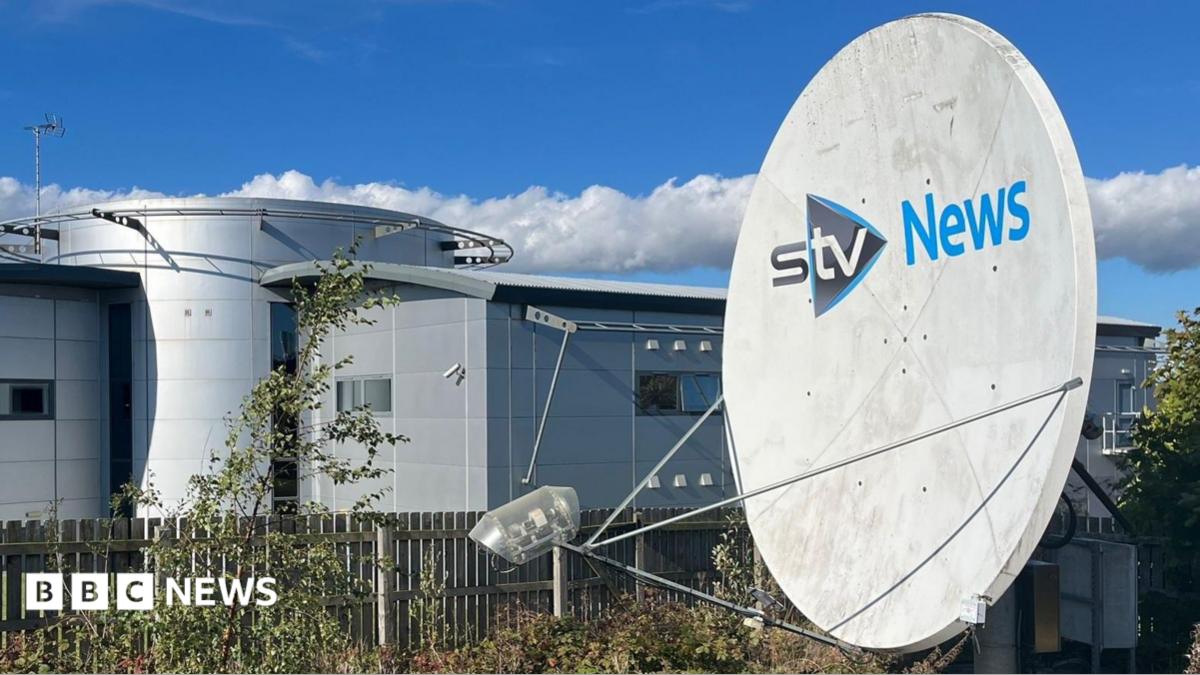 STV News headquarters featuring a large satellite dish, modern architecture, and a clear blue sky with scattered clouds.