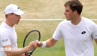 Henry Patten and Harri Heliovaara bump fists after winning a point at Wimbledon